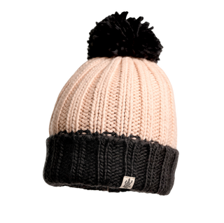 The Cherry Pom Hat is a delightful winter accessory, characterized by its knitted design with a light pink top and black bottom. It boasts a folded brim, a black pom-pom on the top, and features a small white tag with an illustration attached to the brim.