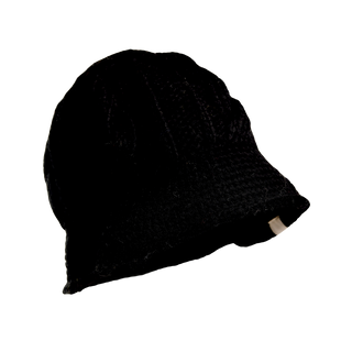 The Nostrand Hat, made from black merino wool, is showcased against a black background. It features a woven texture and a subtle brim, with a tiny white tag visible at the back edge—making it an essential addition to your winter wardrobe.