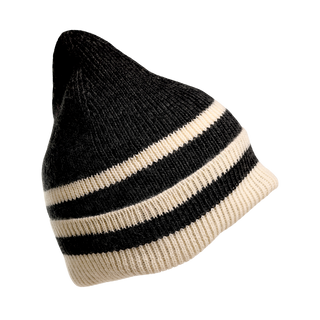 The McGuinness Hat, a modern beanie made from 100% wool, features alternating horizontal black and white stripes with a slightly pointed top and ribbed fabric. The background color of this knit hat is black.