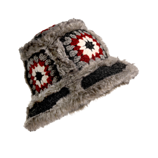 The Crochet Sun Hat With Fur Piping is a standout in cold-weather fashion, featuring colorful crochet square patterns in red, white, and grey, adorned with faux fur piping along the brim and edges.