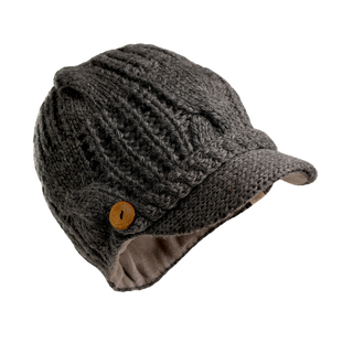 The Broadway Hat is a gray, knitted accessory featuring a visor and textured pattern, complemented by a wooden button detail on the side above the ear flap. It’s an essential winter hat with a cozy, lined interior.