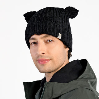 A man wearing the Charlie Hat, a black wool beanie with small cat-like ears, along with a dark jacket and a neutral expression, is photographed against a plain white background.