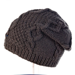A handmade wool Sectional Slouch hat from Nepal on a stand.