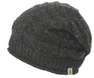 The Wave Slouch is a dark gray beanie with a textured diamond pattern, ribbed brim, and small fabric tag on the edge—your perfect go-to winter hat.