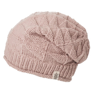The Hand Knit Wave Slouch is a light pink hand loom knit beanie with a geometric pattern, folded ribbed edge, and small fabric tag on the band, shown against a white background.