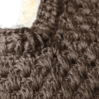 Close-up view of dark brown yarn hand crocheted in a textured pattern for the Hand Crochet Cloud Hood. The stitches appear thick, and the image captures the corner of the crafted piece with a slight glimpse of an off-white material—possibly part of the hood—in the upper left.