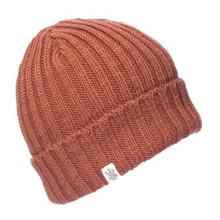 The Clyde Rib Fold Cap is a rust-colored, thickly ribbed merino wool winter hat with a folded brim and a small white rectangular tag on the front, shown against a white background.