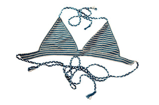 The Bikini Top - Stripes is hand-crocheted with blue and white stripes, showcasing triangular cups and thin braided, adjustable ties around the neck and back. The strap ends are accented with small tassels for a stylish touch.