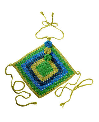 Diamond Top potholder, crocheted in vibrant shades of green, blue, and yellow. It features attached green braided ties at each corner and a central flower design made of three yarn flowers in matching colors. The overall look is symmetrical and colorful.