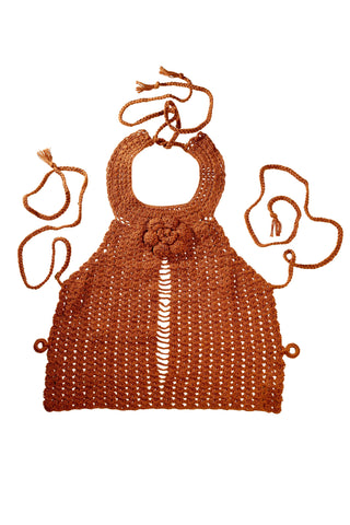 Introducing the Collar Top: a handcrafted brown crocheted piece, designed with a halter neck and adorned with a decorative flower pattern at the center. This stylish top features an open front and is secured by ties at both the neck and back.