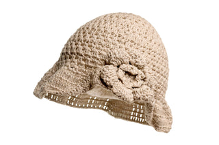 The One Side Turned Up Hat is a beige, crocheted accessory featuring a wide brim and a stylish decorative flower on the side. It boasts a textured pattern that gives it an elegantly handcrafted appearance.