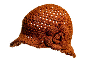 The One Side Turned Up Hat is a brown, crocheted cloche hat with intricate openwork designs. It features a decorative, crocheted flower on the side against a white background.