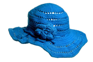 The Flower Sun Hat, a blue crocheted hat with a wide brim and detailed stitching patterns, is displayed. This hat features a decorative crocheted flower on the side.