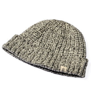A Hand Knit Grid hat in gray and white Merino wool, featuring a ribbed cuff and a small rectangular tag on the cuff, displayed against a white background.