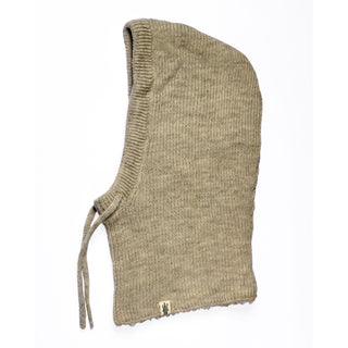 The Hand Knit Cozy Hood—a tan, ribbed balaclava—lies flat on a white background. Made from hand knit wool, it features a comfortable hooded design with two neck ties and a small rectangular tag near the hem.