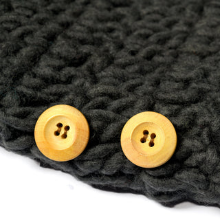 Here is a revised version of your sentence using the given product data: Close-up of two light wooden buttons sewn onto thick, dark gray knitted fabric. Each button has four holes and they are aligned parallel to each other near the edge, adding a charming accent to this Hand Crochet Acorn Hat made from chunky wool yarn.
