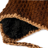 Close-up of the Hand Crochet Grizzly Hat, featuring thick brown and tan wool with braided ties and a soft black sherpa lining, displayed on a white background.