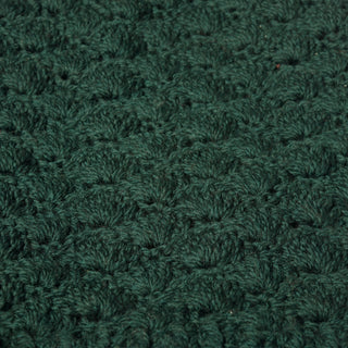 Close-up of the Hand Knit Puff Beanie in dark green, highlighting the repeating textured pattern and visible yarn fibers—showcasing the soft detail characteristic of hand-knitted fabric. The image focuses solely on the beanie, with no additional objects or decorations present.