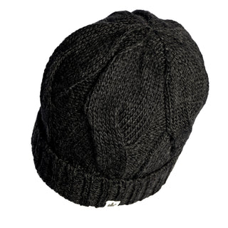 A dark gray Hand Knit Nord Hat with a visible ribbed cuff and textured patterns. Designed for both style and warmth, this beanie features a cozy fleece lining. The Hand Knit Nord Hat is photographed from above on a white background.