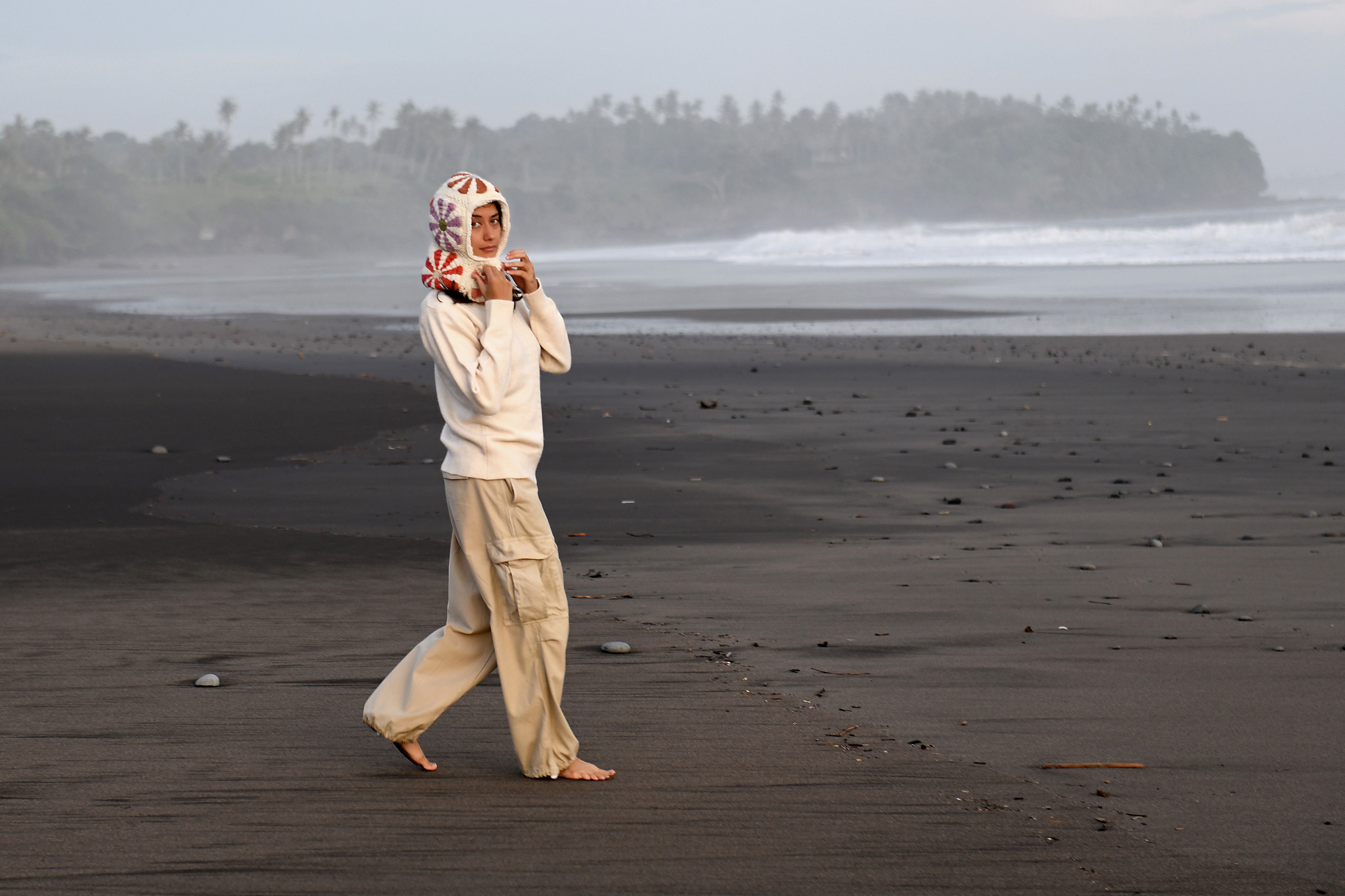 Hand-knit wool hood worn on a black-sand beach