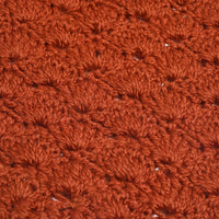 Close-up of a textured, rust-colored Hand Crochet Veil Scarf featuring a repeating pattern of raised, rounded stitches. The thick yarn has a slightly fuzzy appearance, beautifully highlighting the textured bobble stitch that adds cozy charm to this handcrafted accessory.