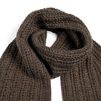The Hand Crochet Velour Scarf, a dark brown ribbed knit accessory crafted from soft Merino wool, is displayed on a white background with one end loosely knotted over the other.