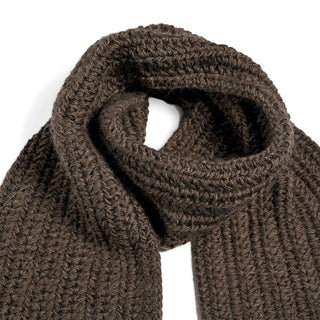 The Hand Crochet Velour Scarf, a dark brown ribbed knit accessory crafted from soft Merino wool, is displayed on a white background with one end loosely knotted over the other.