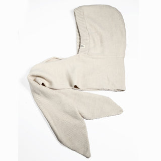 A Hand Loom Nomad Hood Scarf in beige, featuring two long, pointed ends and a hand-knit appearance, is displayed flat on a white background. The soft, flexible fabric evokes the style of historical or medieval hoods.