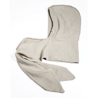 A Hand Loom Nomad Hood Scarf in beige is displayed laid flat on a white background. The soft, textured fabric features a hand knit look with simple, clean edges and an attached long scarf, free from visible patterns or embellishments.