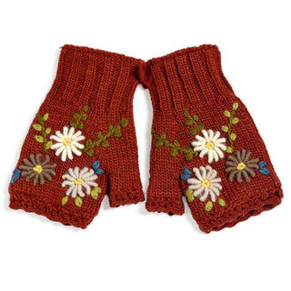 Introducing the Hand Knit Bloom Mittens: a pair of rust-colored, fingerless wool gloves adorned with delicate embroidered flowers in white, yellow, green, and blue yarn on the backs. These cozy hand warmers are displayed side by side on a white background.
