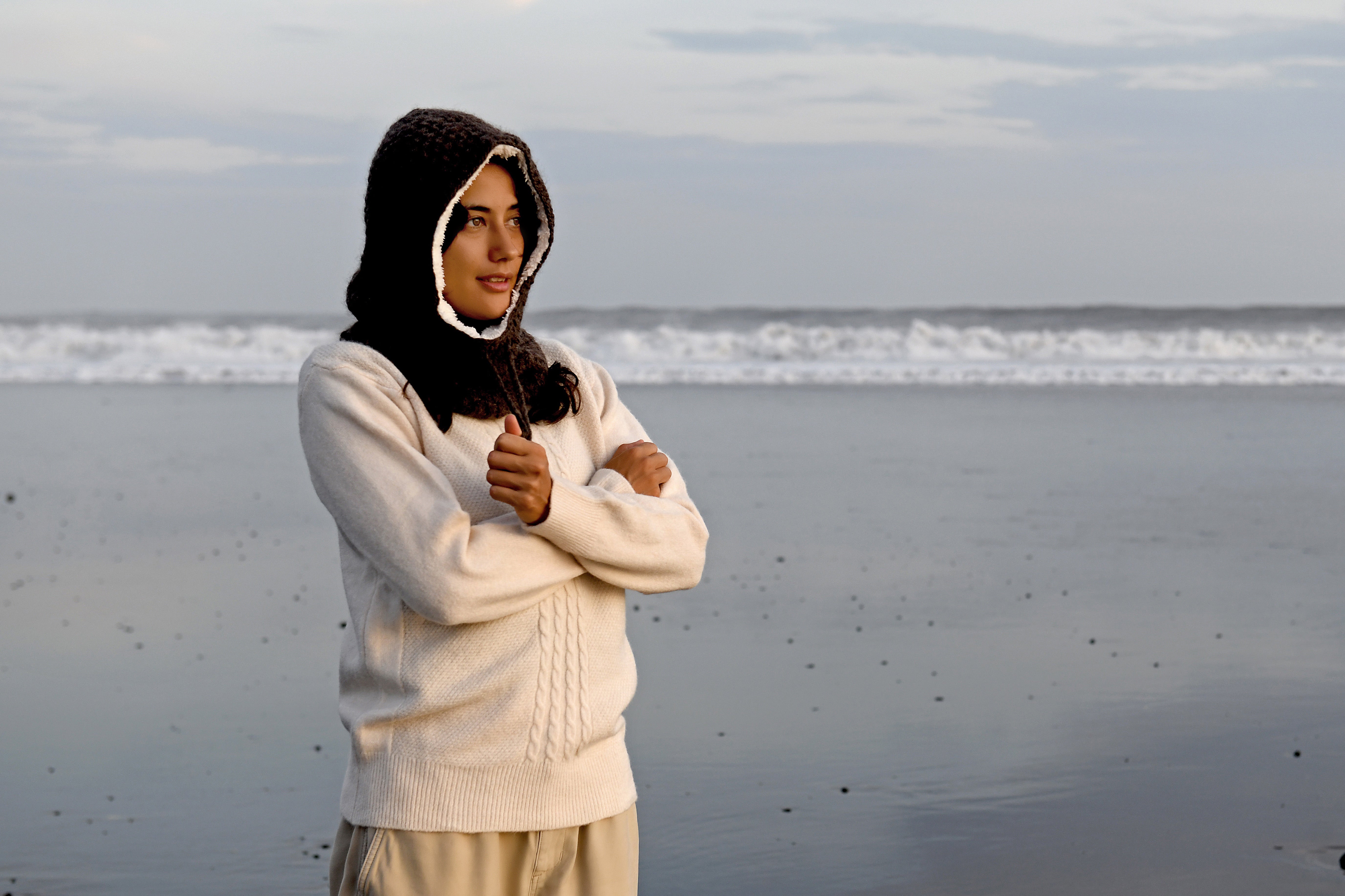 Hand-knit wool hood worn on a black-sand beach