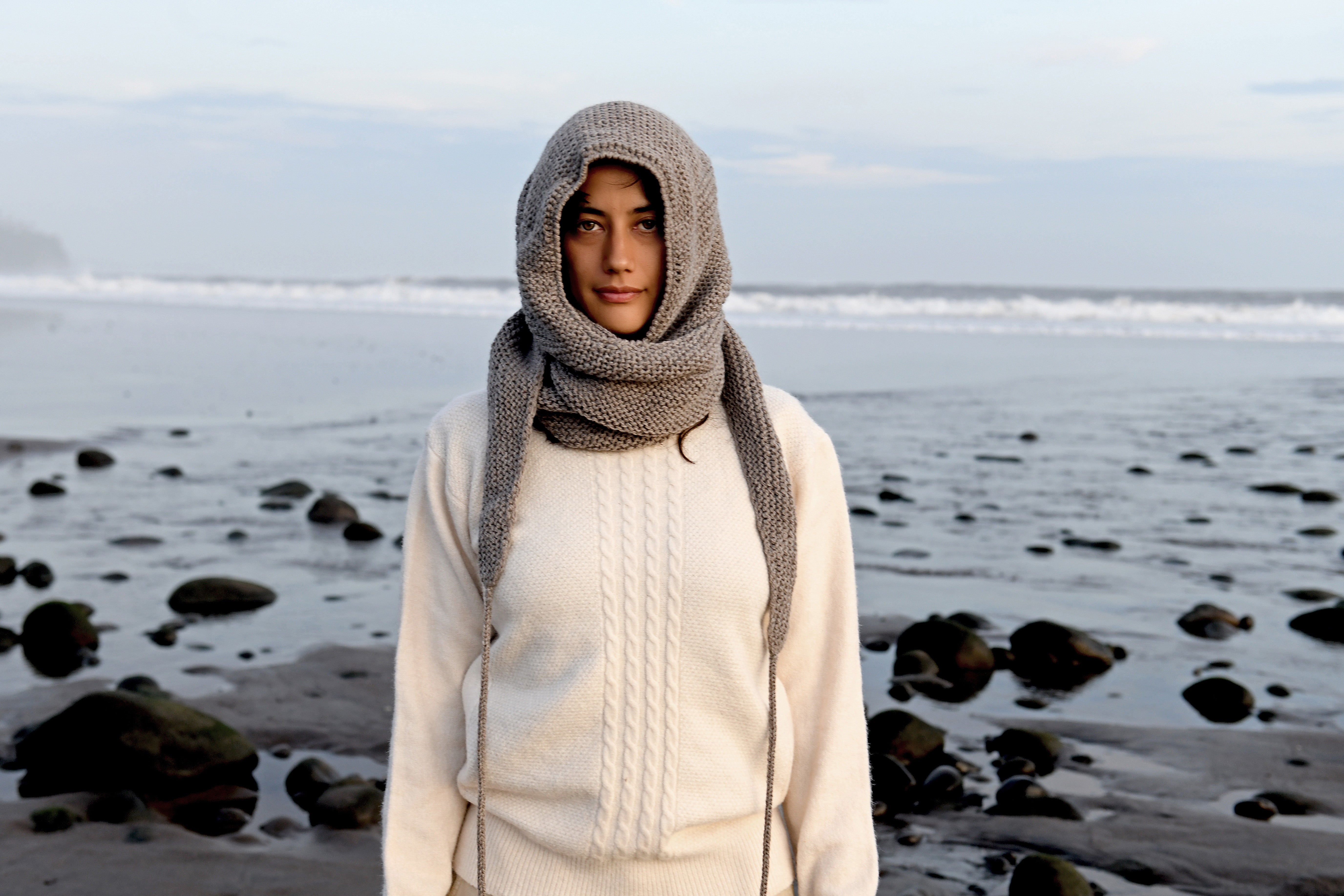 Hand-knit wool hood worn on a black-sand beach