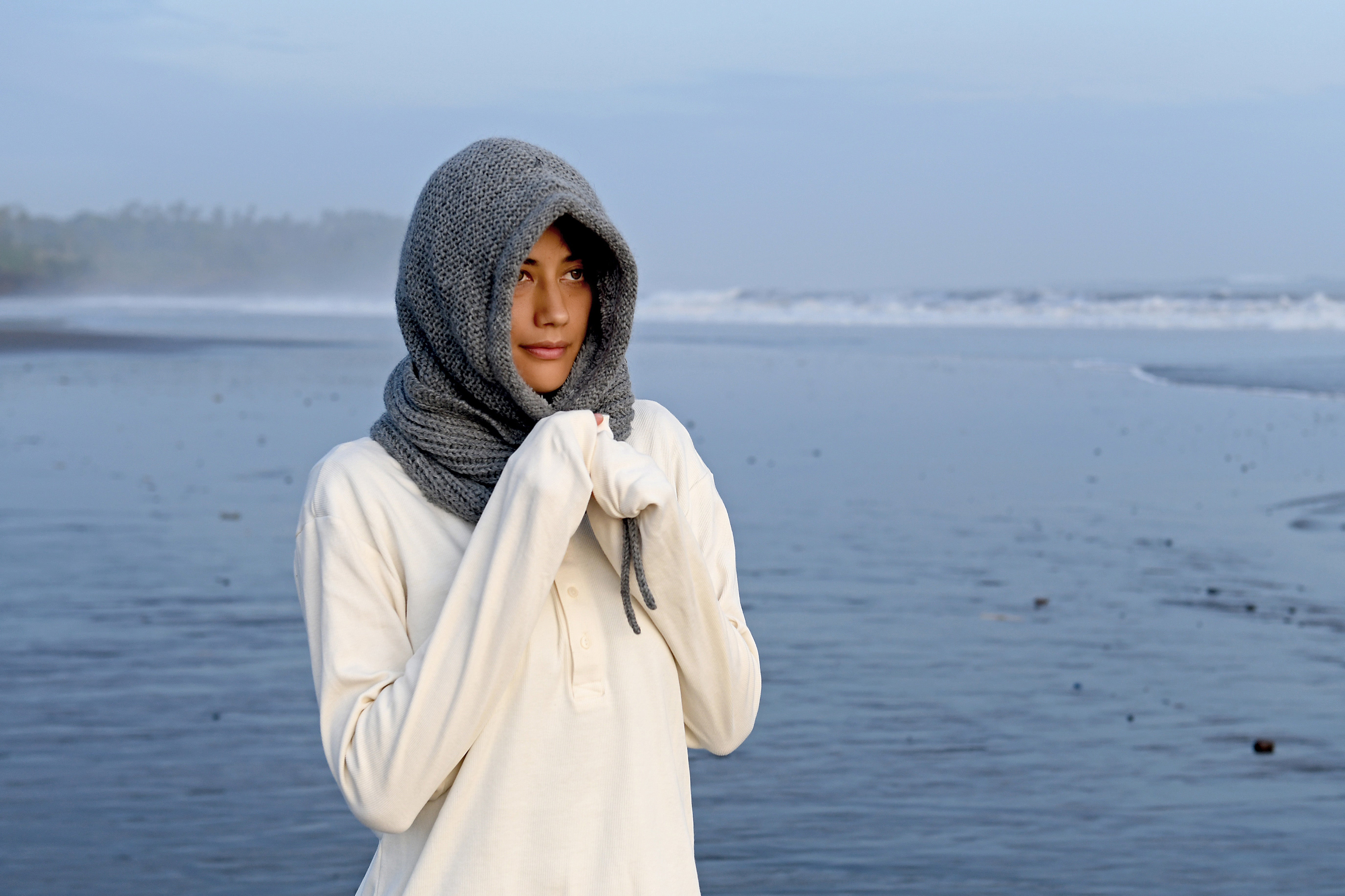 Hand-knit wool hood worn on a black-sand beach