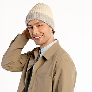 A man wearing the beige Cliff Hat stands against a plain white background, smiling and touching the side of his head.