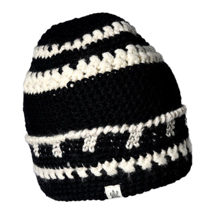 The Hand Crochet Discover Hat is displayed against a white background, showcasing black and white horizontal and zigzag stripe patterns. It features a striped fold-cuff design with a small white label attached to the bottom edge.