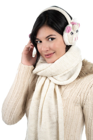 A woman in a cream hand-knit wool sweater and matching scarf wears Hand Knit Unicorn Earmuffs—white with animal ears and face—while smiling slightly against a white background.