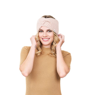 A woman wearing a tan sweater and a Tuk headband.