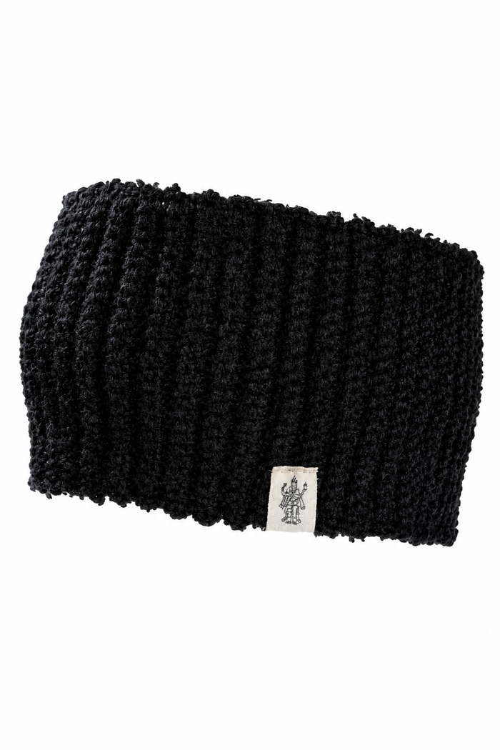 The Hand Loom Mandy Headband is a black, ribbed wool headband handmade in Nepal, featuring a small white tag with a line drawing of a figure with raised arms. Shown against a plain white background.