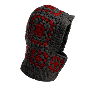 The Crochet Patch Hood is a woolen hood featuring a pattern of red and gray crochet squares. It boasts a textured, handmade appearance and provides coverage for both the head and neck. The gray base color is highlighted by red floral motifs within each square, and it comes with a soft, insulated lining.