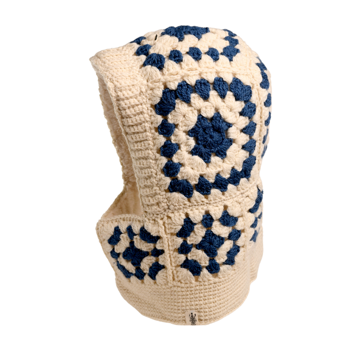 The Hand Crochet Patch Hood is a cream and navy blue hand-crocheted wool accessory featuring a classic granny square pattern in a striking geometric design. Covering both the head and neck, it stands out beautifully against a plain white background.