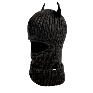 The Hood With Horns is a black, handcrafted wool balaclava featuring pointed horn-like details on top and an eye-opening. Its thick, ribbed texture and turned-up cuff make it the perfect winter accessory for cold weather.