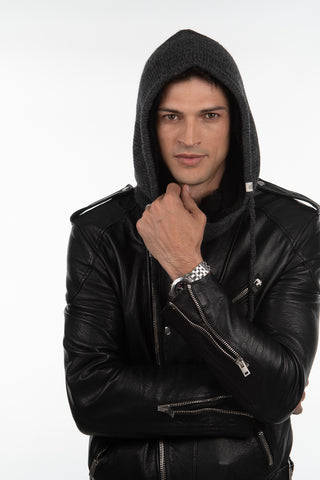 A man in a black leather jacket and the Hand Loom Hero Hood touches his chin and looks at the camera against a plain white background.