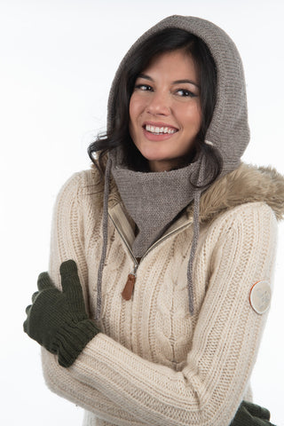 Smiling woman in a beige Hand Loom Hero Hood with fur trim and matching scarf, arms crossed, wearing dark green gloves—a cozy winter accessory—against a plain white background.