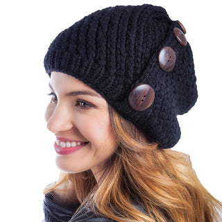 A woman with a warm smile wearing a Four Button Knit Beret Cap adorned with three wooden buttons.