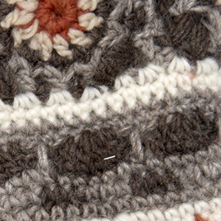 Close-up of the textured, flower-like stitches on Dreams Hand Crochet Handwarmers, crafted in Nepal from cozy gray, white, and brown yarn.