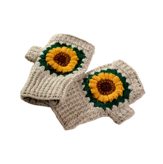 Introducing the Sunflower Handwarmers, a pair of crocheted fingerless gloves crafted from gray yarn. Each glove features a central sunflower motif with yellow petals, a brown center, and a green border, all set against a ribbed texture.