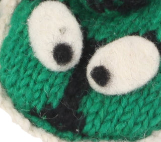 Close-up of Hand Knit Dinosaur Mittens in green and black, featuring two large, white, felted eyes with black pupils.