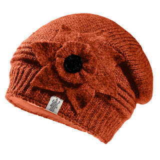 The Monroe Hat is a handmade orange knit wool beanie from Nepal, featuring a large fabric flower with a dark center on one side and a small logo tag near the bottom edge for unique charm.