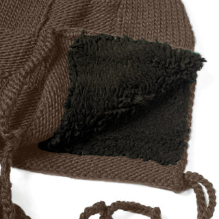Close-up of the Hand Knit Nest Hat, featuring cozy earflaps lined with soft black fleece on the inside. Two braided strings attached to the earflaps are visible in the foreground, emphasizing the warm and handmade design of this Nepalese knit hat.