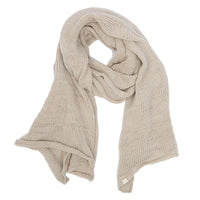 The Hand Loom Air Wrap Scarf in beige, featuring a soft texture and slightly chunky weave, is loosely arranged on a white background with its ends laying unevenly.